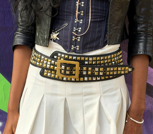 Person wearing a studded belt with a colorful background